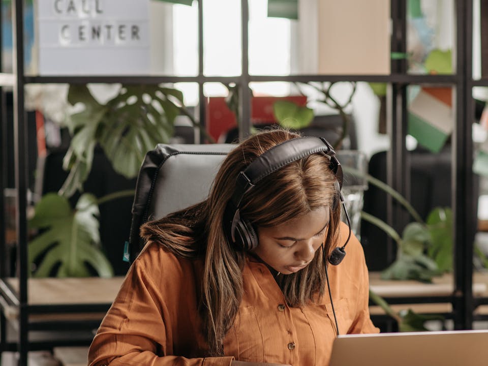 Ejecutiva de atención al cliente en oficina de contact center gestionando soporte postventa
