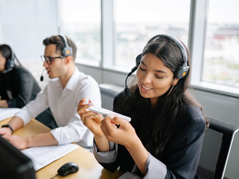 Agente de contact center latina con audífonos trabajando en operación de cobranza